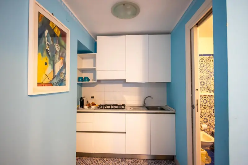 Une cuisine lumineuse avec des meubles blancs et un carrelage décoratif.