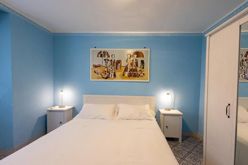 Une chambre lumineuse avec un lit double et une décoration murale colorée.