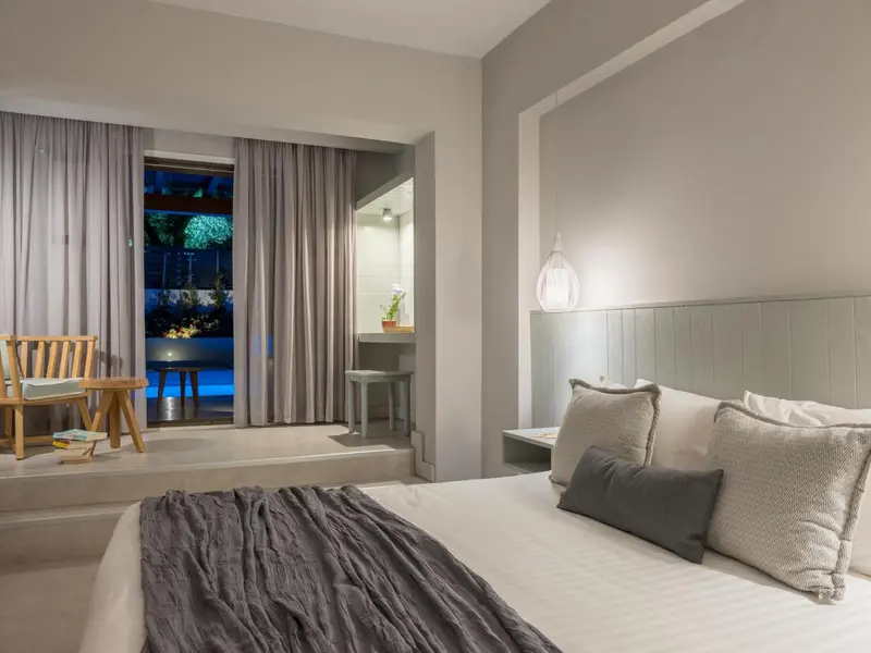 Une chambre lumineuse avec un grand lit et un accès à une terrasse.