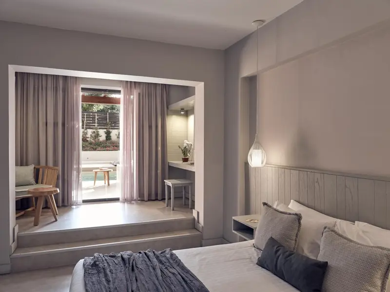 Une chambre lumineuse s'ouvre sur une terrasse avec mobilier.