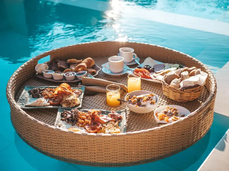Un plateau de petit-déjeuner est présenté au bord d'une piscine.
