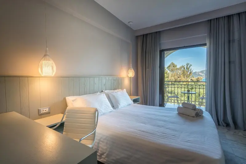 Une chambre lumineuse avec un grand lit et une vue sur la mer.