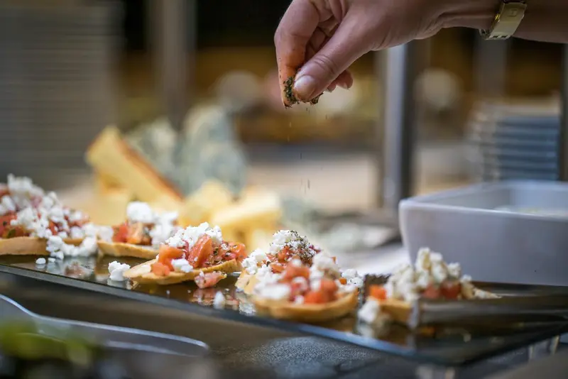 Préparation de canapés à base de tomates et de fromage frais.