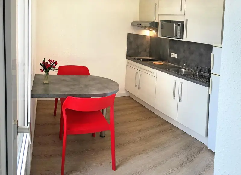 Une cuisine moderne avec un plan de travail et des meubles blancs.