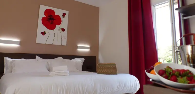 Une chambre avec un grand lit recouvert de draps blancs et d'oreillers.