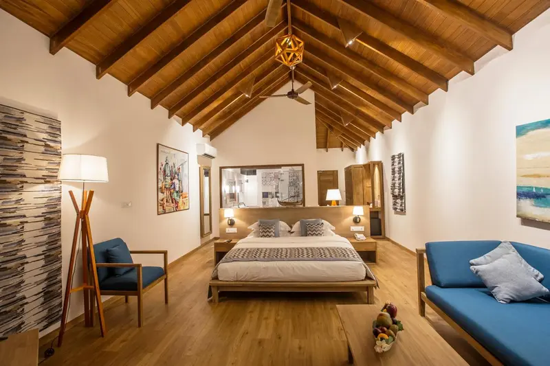 Une chambre lumineuse avec un lit double et un coin salon.