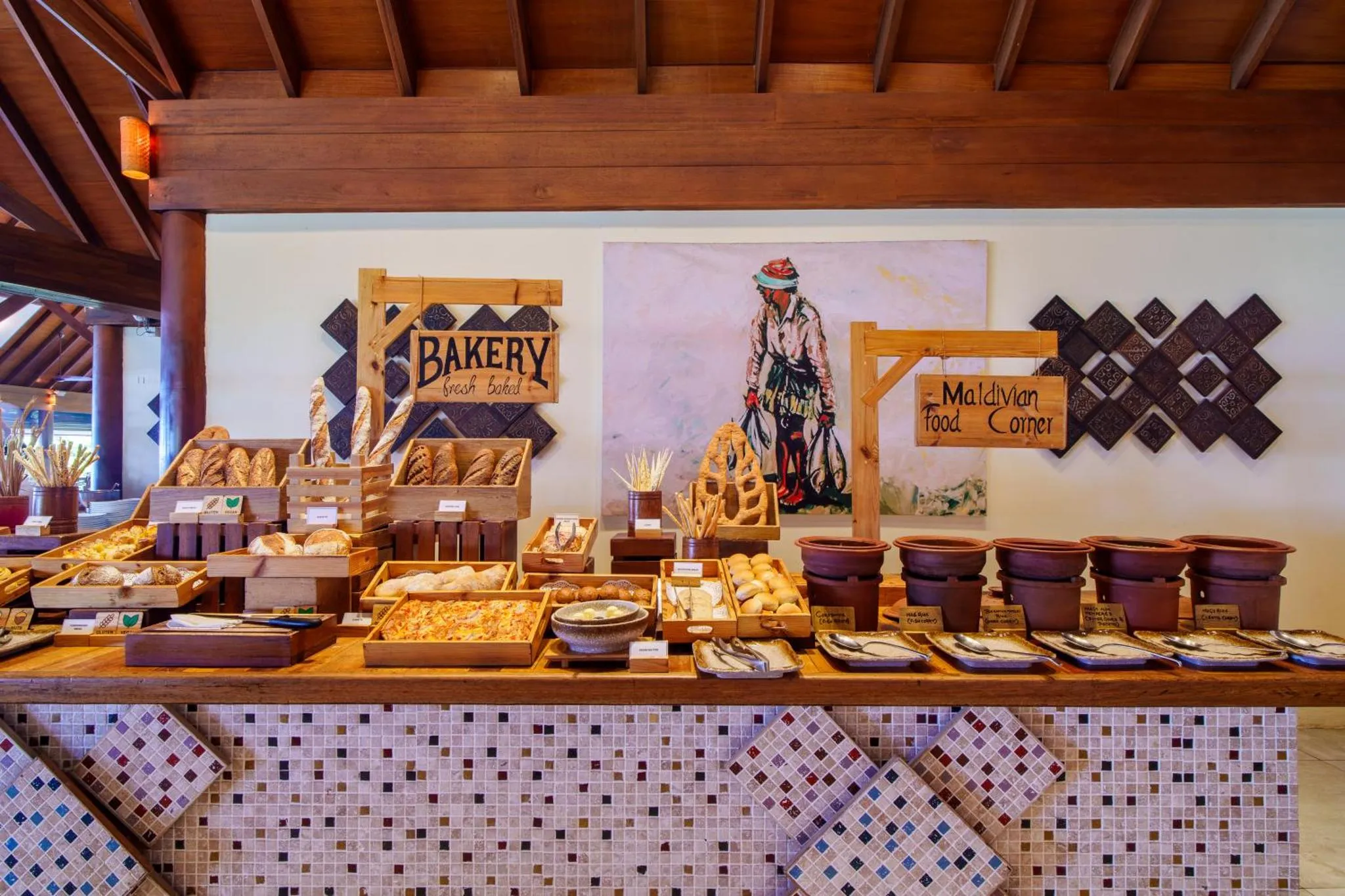 Un buffet propose une variété de pains et de pâtisseries sur un comptoir décoré.