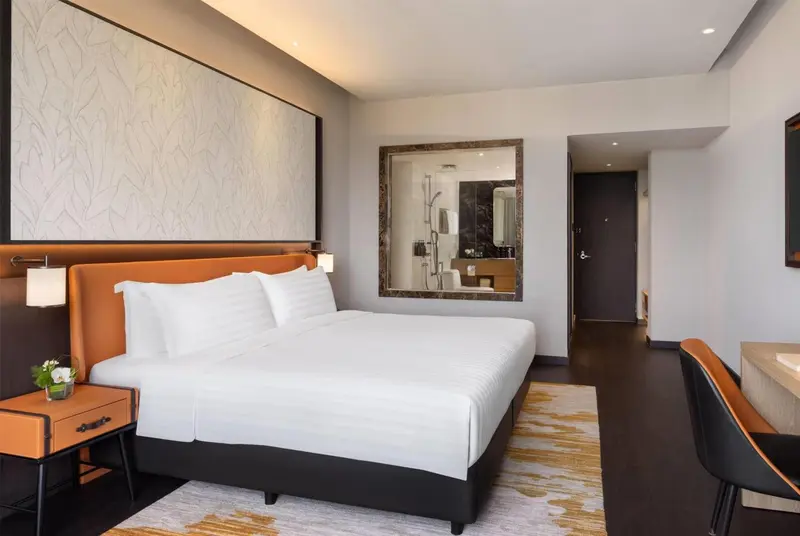 Une chambre moderne avec un grand lit et un miroir décoratif.