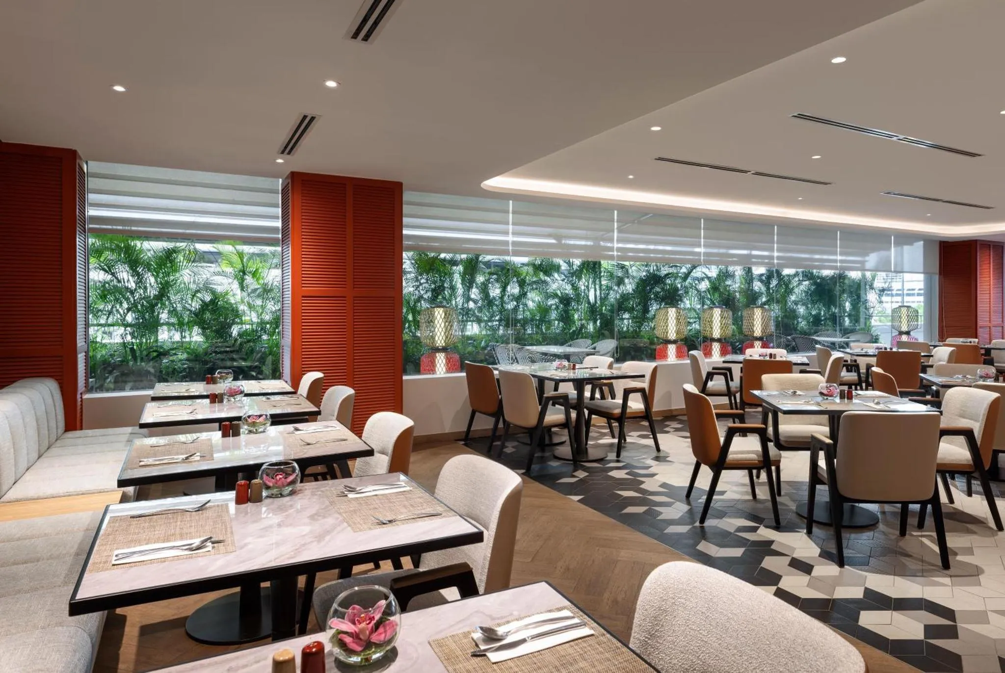 Une salle lumineuse avec des tables dressées pour le repas.