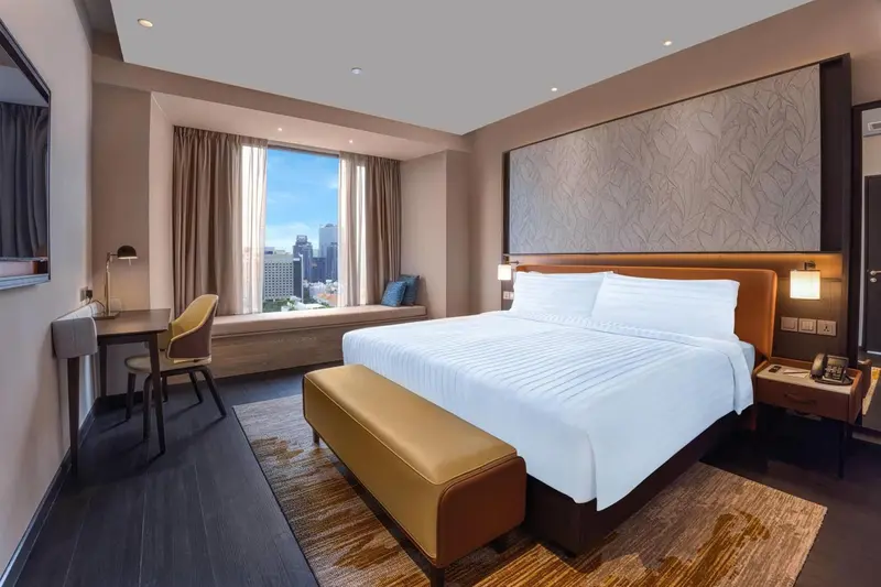 Une chambre d'hôtel lumineuse avec un grand lit et une vue sur la ville.
