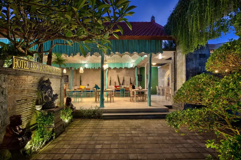 Terrasse ombragée avec tables et chaises disposées pour les repas.