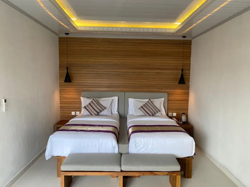 Une chambre lumineuse avec deux lits simples et une décoration moderne.
