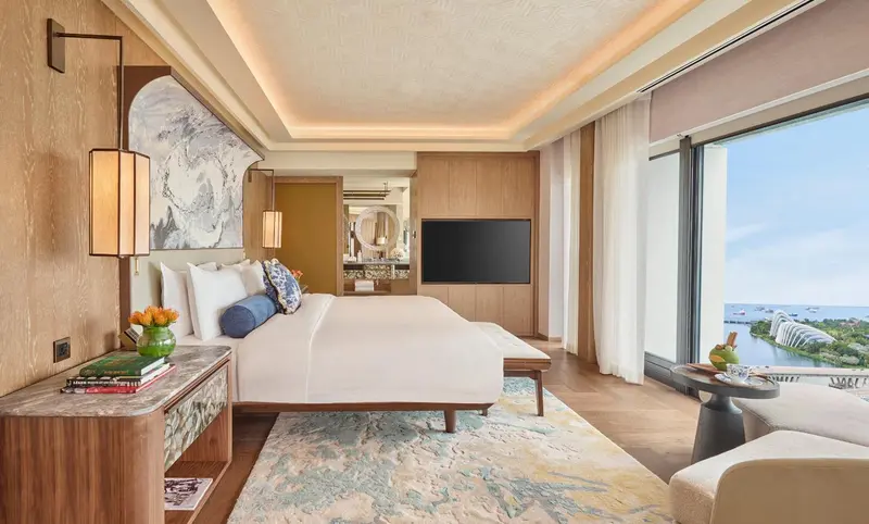 Chambre lumineuse avec un grand lit et une vue sur la mer.