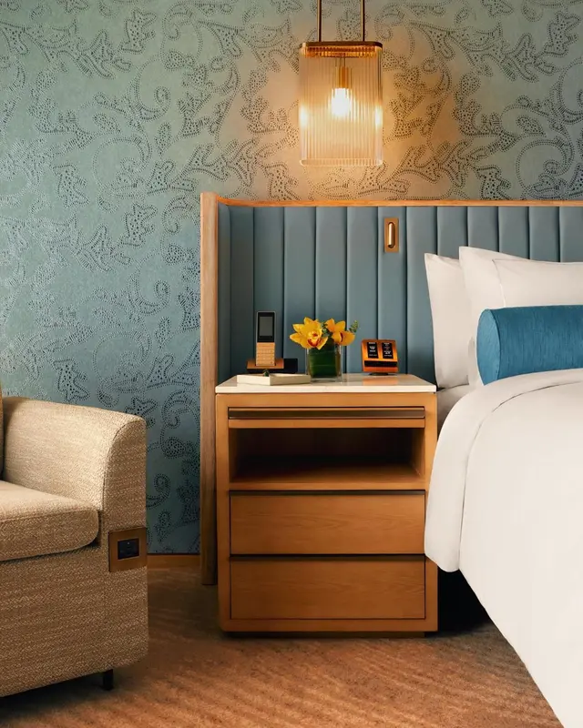 Une chambre d'hotel avec un lit et une table de chevet.