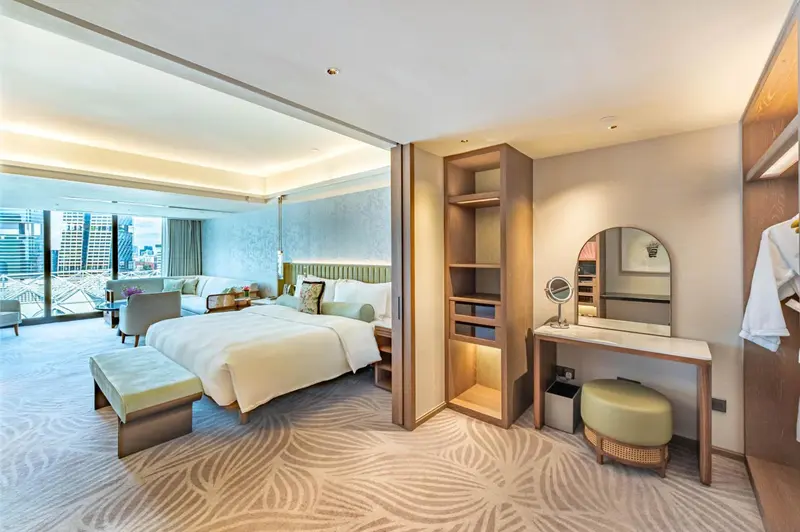 Une chambre lumineuse avec un grand lit et un coin salon.