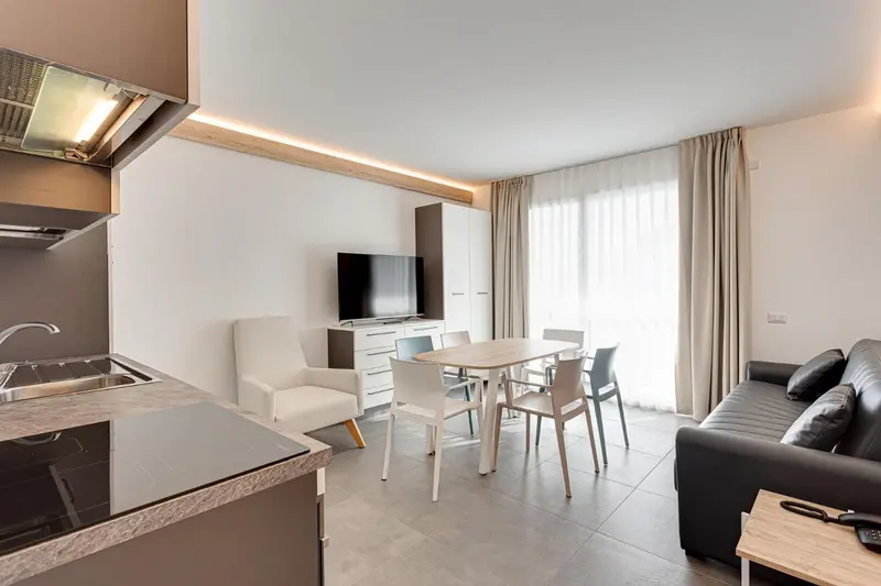 Espace de vie lumineux avec cuisine équipée et coin repas.