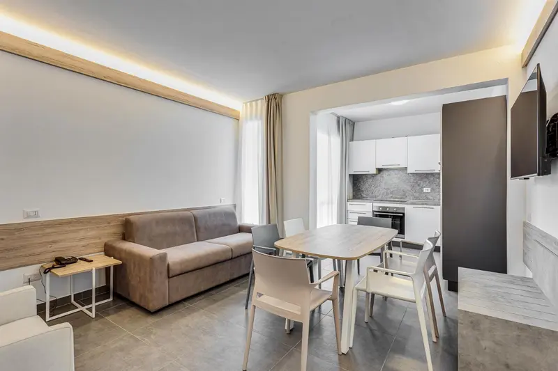 Espace de vie lumineux avec canapé, table à manger et cuisine ouverte.