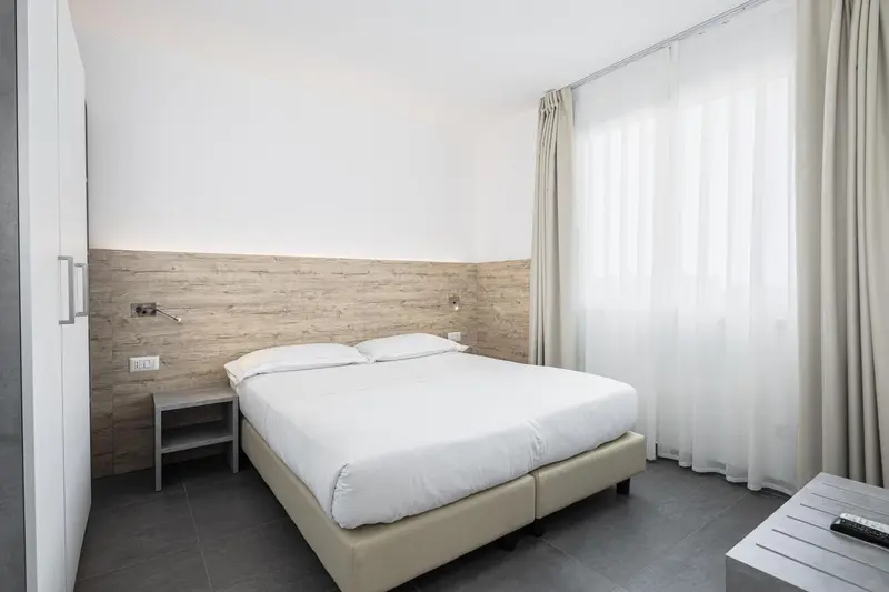 Une chambre lumineuse avec un grand lit et une décoration sobre.
