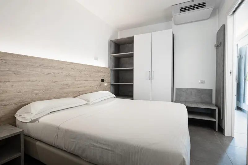 Une chambre lumineuse avec un grand lit et des rangements.
