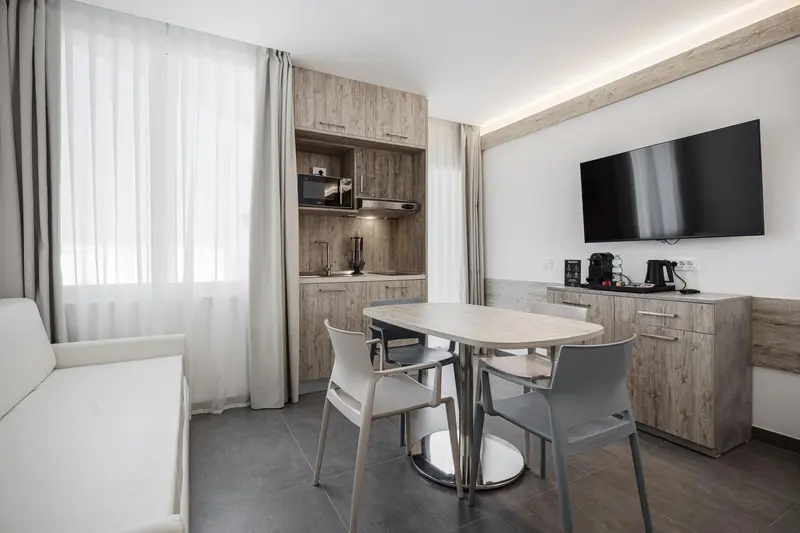 Une pièce lumineuse avec un coin repas et une kitchenette intégrée.