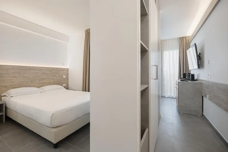 Une chambre lumineuse avec un lit double et un espace de rangement.