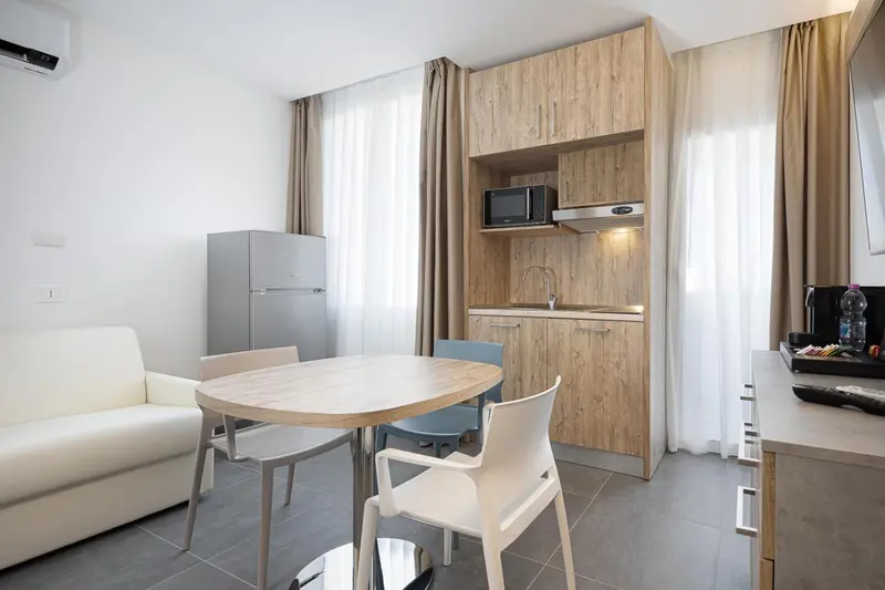 Espace de vie avec coin repas et kitchenette intégrée.
