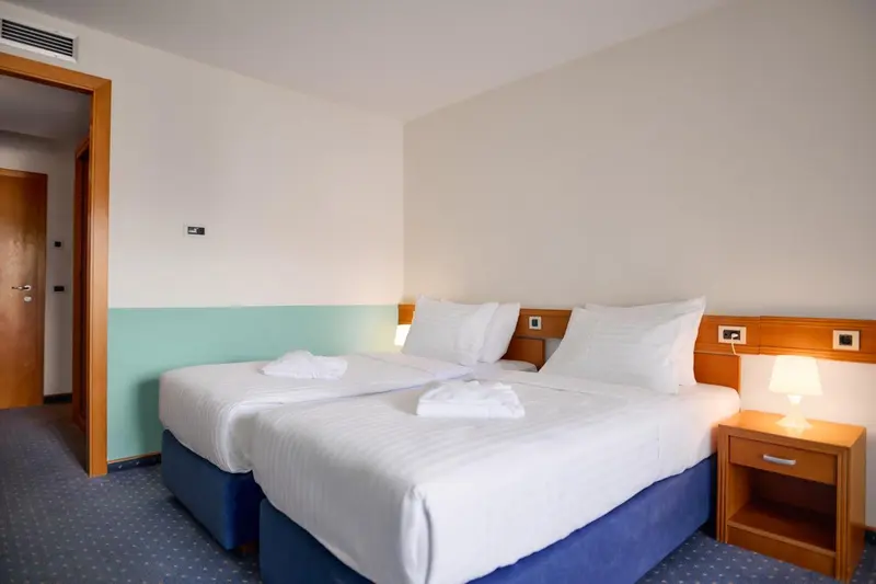 Une chambre avec deux lits simples et des tables de chevet.