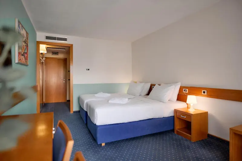 Une chambre lumineuse avec un grand lit et une décoration sobre.
