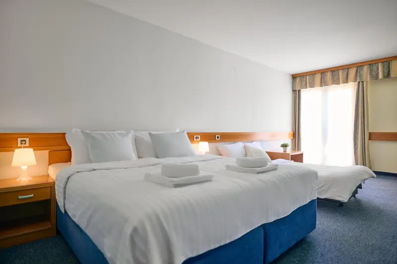 Une chambre lumineuse avec un grand lit et une décoration sobre.