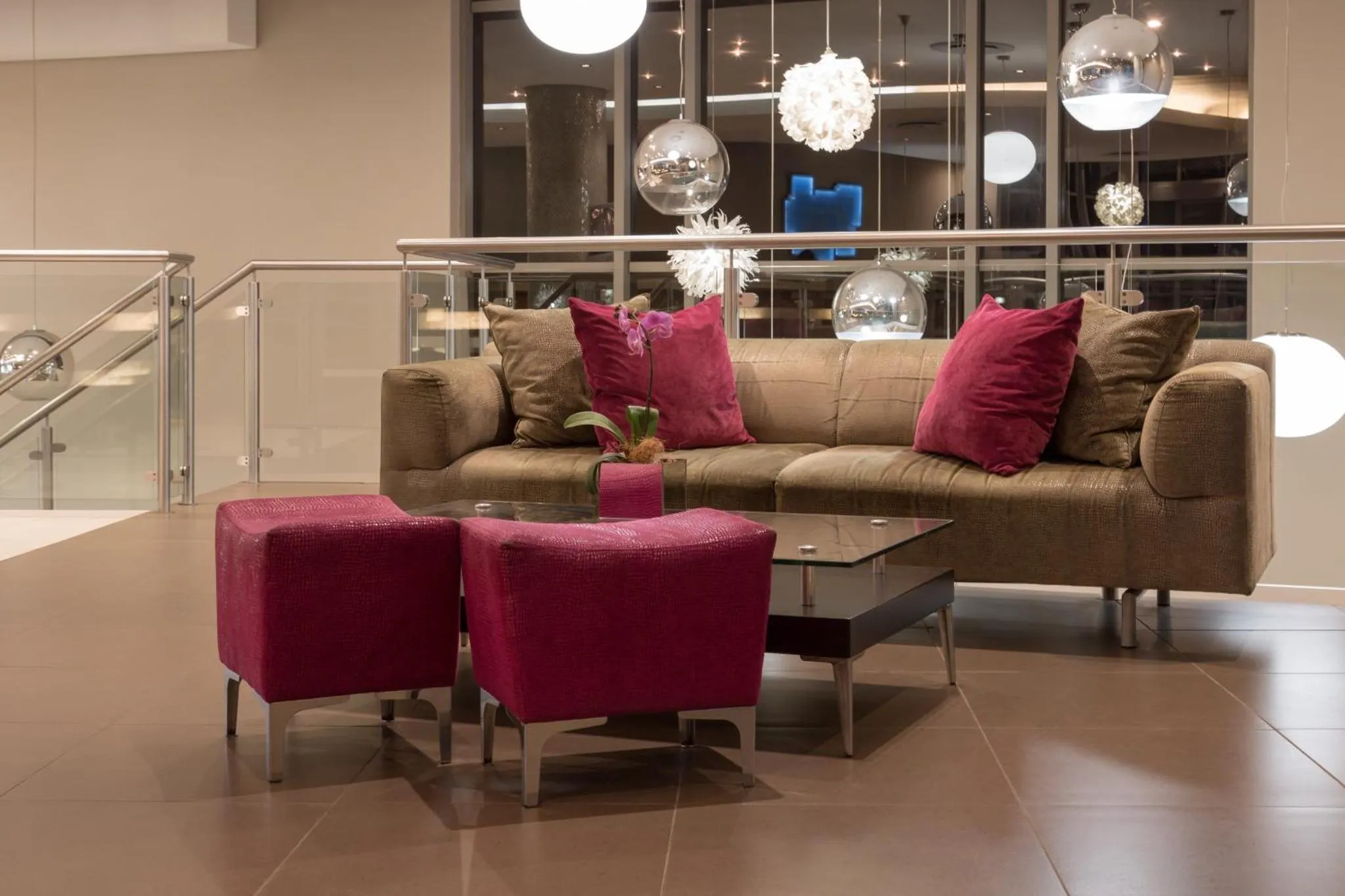 Un espace de détente avec canapé et poufs roses.