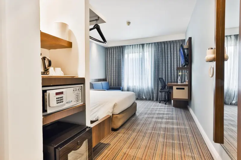 Une chambre d'hôtel moderne avec un lit double et un coin bureau.