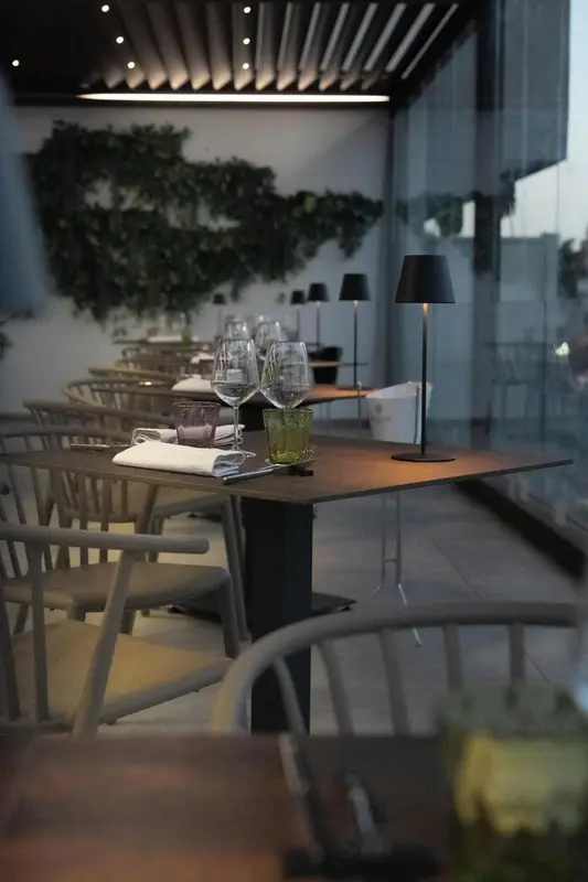 Une table dressée dans une salle à manger lumineuse avec une vue sur la végétation.
