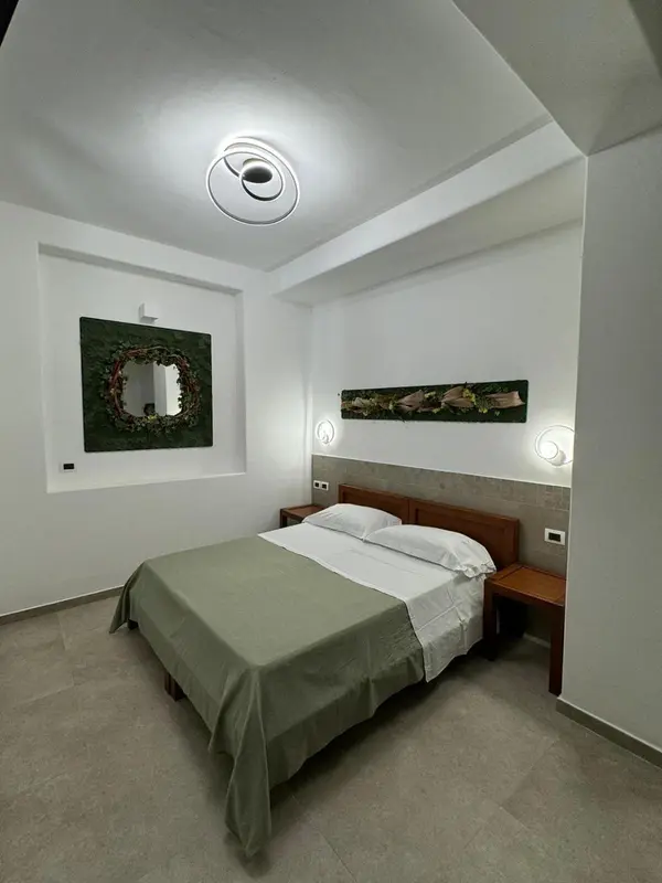 Une chambre lumineuse avec un lit double et des œuvres murales.