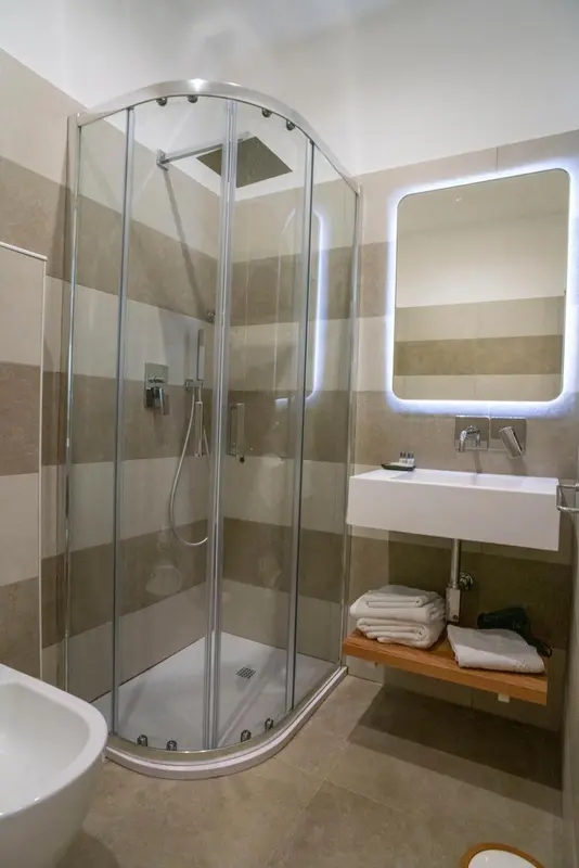 Une douche à l'italienne moderne dans une salle de bain carrelée.
