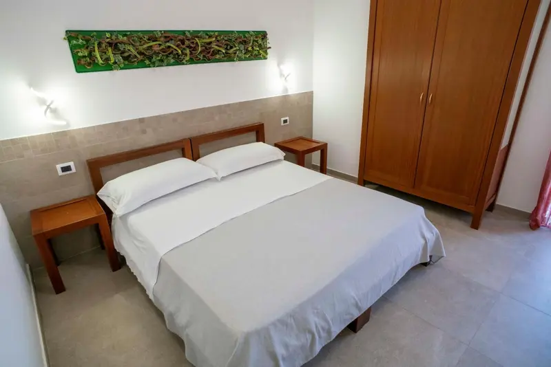 Une chambre lumineuse avec un grand lit et une armoire en bois.