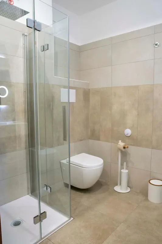 Une salle de bain moderne avec douche à l'italienne et carrelage beige.