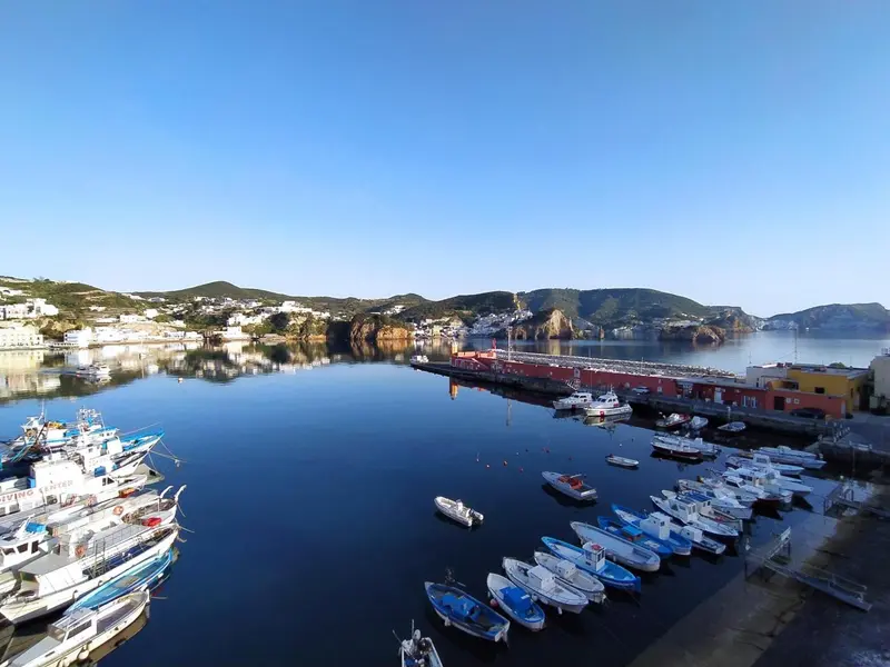 Vue aérienne d'un port de plaisance abrité par une côte rocheuse.