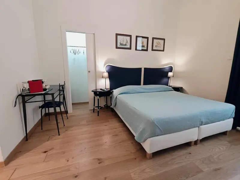 Une chambre lumineuse avec un grand lit et un bureau.