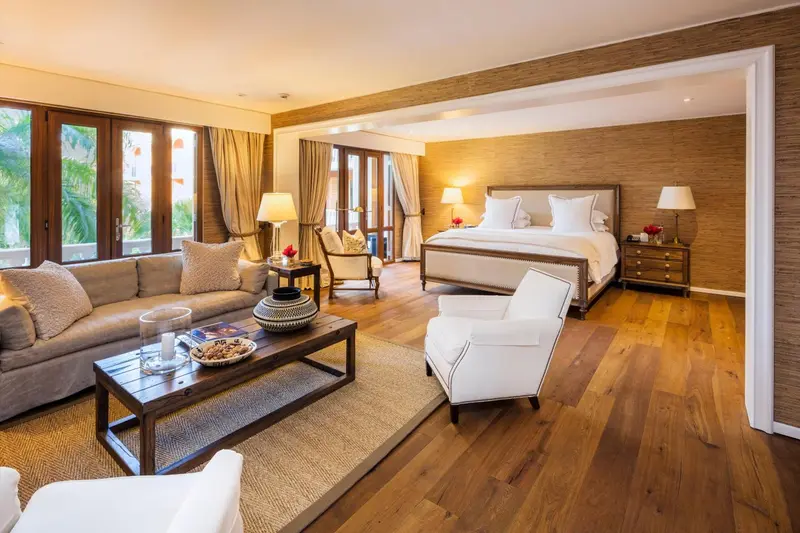 Une chambre spacieuse avec canapé, fauteuils et grand lit.