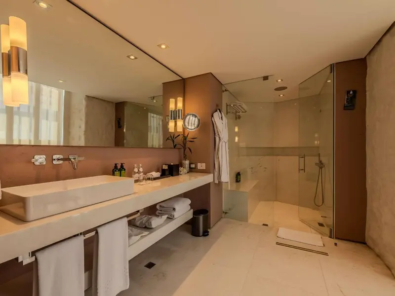 Une salle de bain moderne avec une grande douche vitrée et un double vasque.