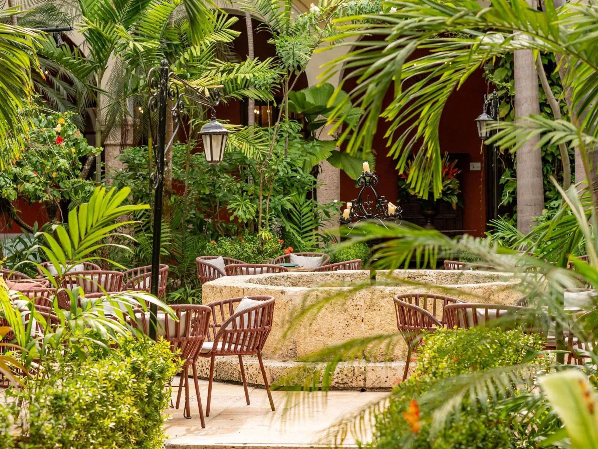 Un espace extérieur aménagé avec des tables et des chaises autour d'une fontaine.