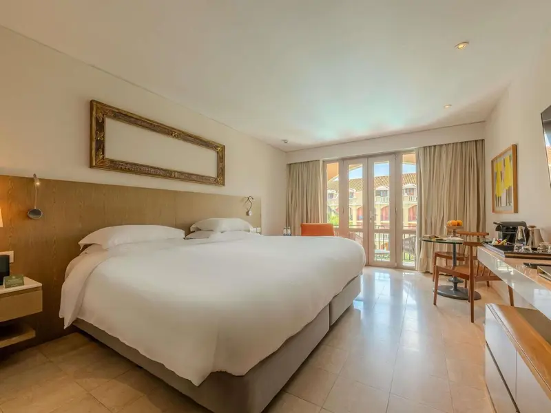 Une chambre lumineuse avec un grand lit et un coin salon.