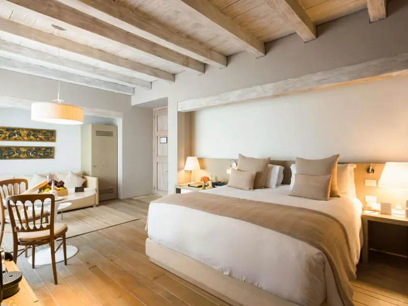 Une chambre lumineuse avec un lit double et un coin salon.