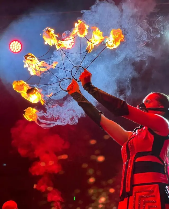Une personne manipule des torches enflammées lors d'une performance.