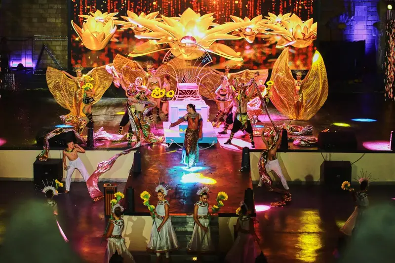 Spectacle avec des danseurs costumés sur une scène illuminée.