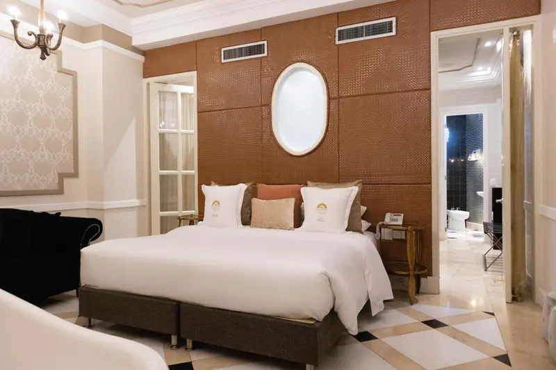 Une chambre lumineuse avec un grand lit et une décoration soignée.