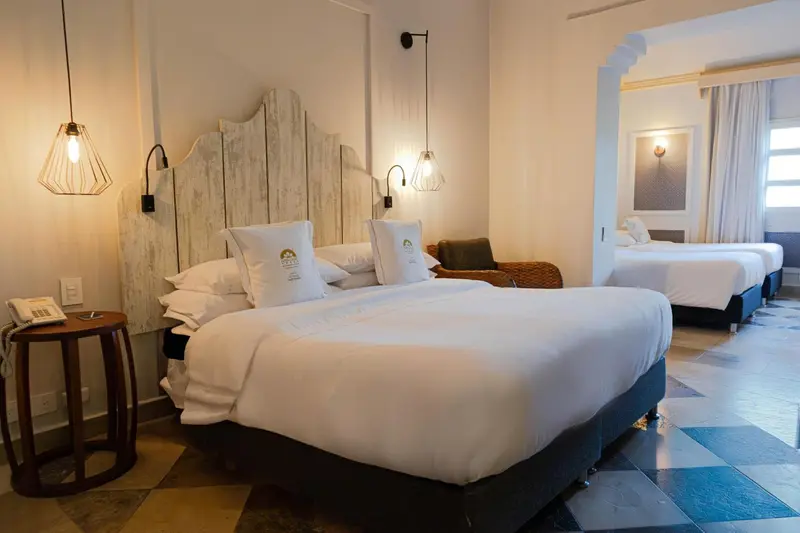 Chambre lumineuse avec deux lits simples et une décoration soignée.