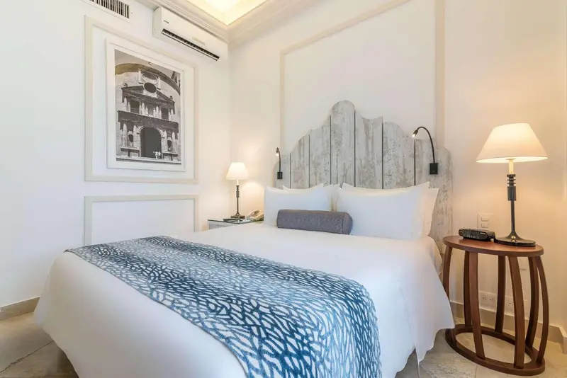 Une chambre lumineuse avec un grand lit recouvert d'une courtepointe décorative.