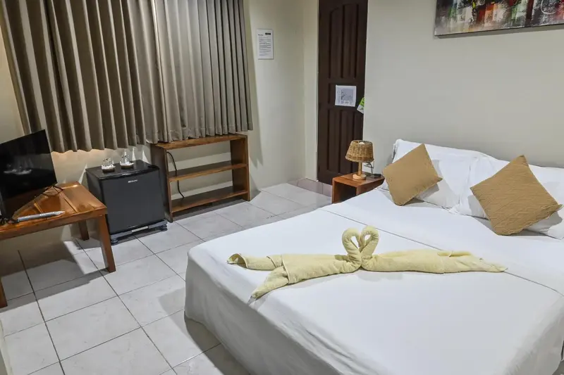 Une chambre lumineuse avec un lit recouvert d'une décoration en serviette.