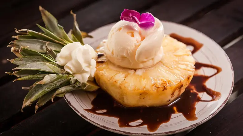 Une portion de dessert à base de glace et d'ananas est présentée sur une assiette.